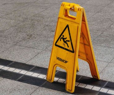 a yellow Slippery Surface Sign on floor