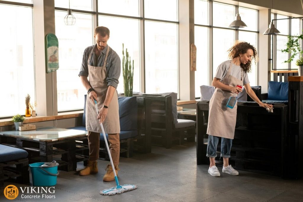 A restaurant owner mopping restaurant concrete floor