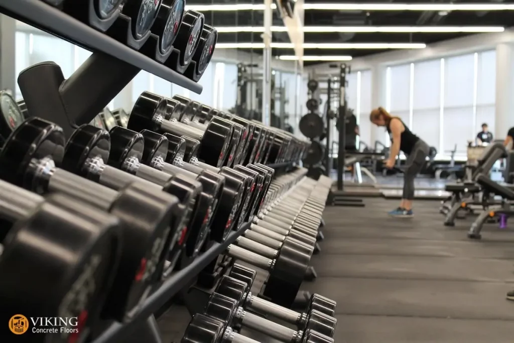 A woman working out in a gym coated with concrete flooring in Prairieville, LA