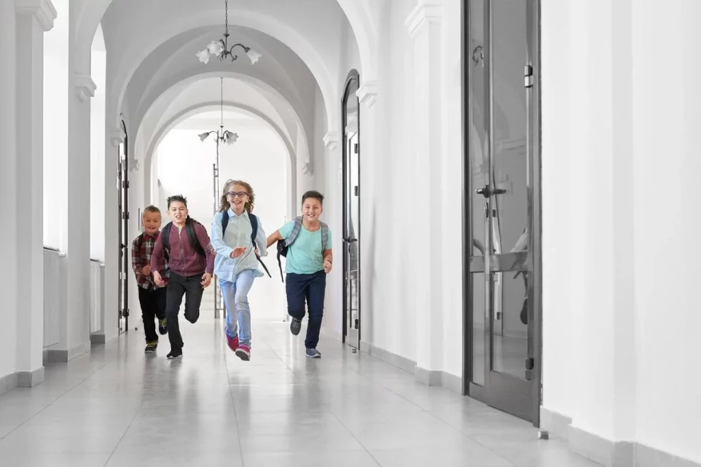 Children running on polished concrete flooring in school