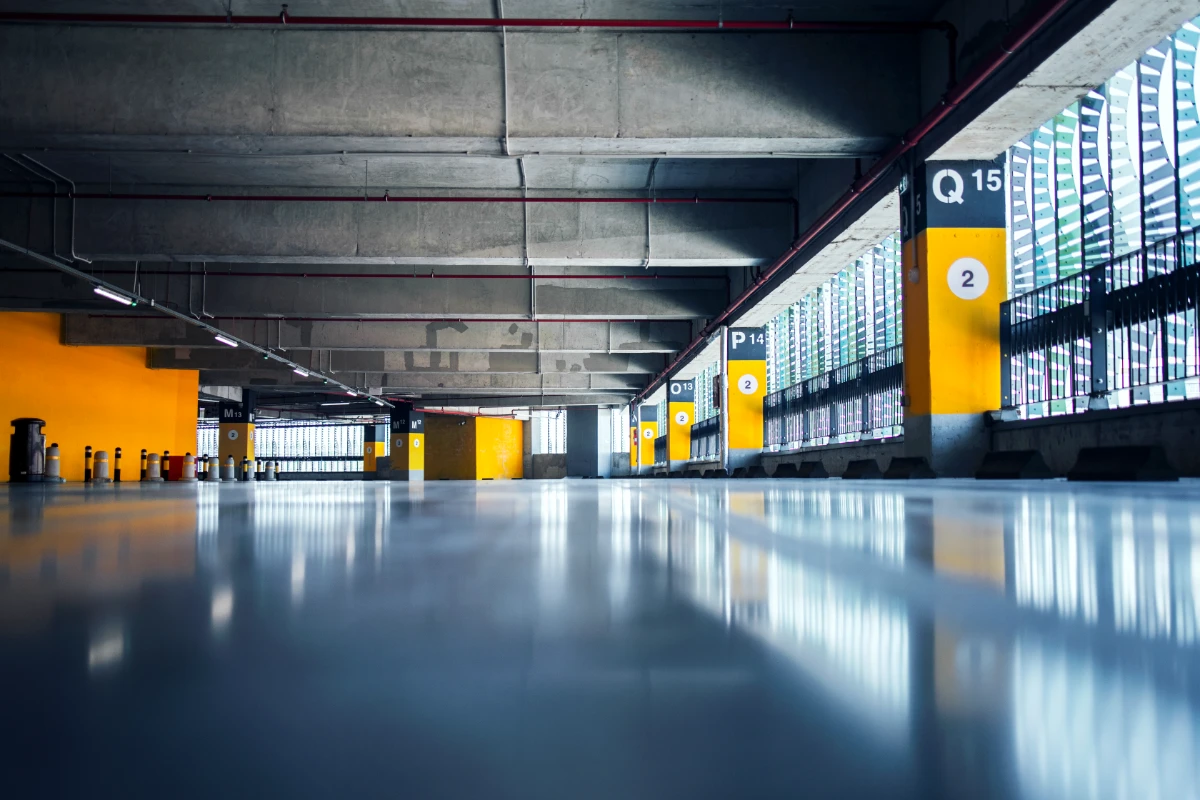 empty garage with parking lots with concrete ceiling and flooring and pillars marked with numbers